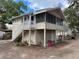 View of two-story home with large screened porch and white stairs leading to the entrance at 113 W 19Th St, Sanford, FL 32771