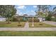 Green house with landscaped yard and walkway at 1296 W Wellington Dr, Deltona, FL 32725