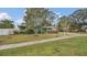 Green house with a landscaped lawn and driveway at 1296 W Wellington Dr, Deltona, FL 32725