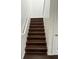 Modern staircase with dark brown laminate treads and white railing at 14324 Fieldstone Lake Way, Orlando, FL 32824