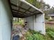 Small covered patio area with storage shelving and concrete flooring at 1504 Laun Pl, Lakeland, FL 33803