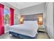 Bedroom with king-size bed and red curtains at 1549 Corolla Ct, Reunion, FL 34747