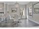 Modern glass dining table with white chairs and a chic chandelier at 1549 Corolla Ct, Reunion, FL 34747