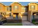 Tan two-story townhome with two-car garage, basketball hoop, and landscaped front yard at 16583 Cedar Crest Dr, Orlando, FL 32828