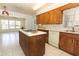 Open kitchen with island, dishwasher, and wood cabinets at 2201 Sunderland Rd, Maitland, FL 32751