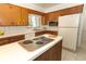 Kitchen features an island with cooktop and lots of cabinets at 2201 Sunderland Rd, Maitland, FL 32751