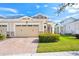 Charming home featuring a manicured lawn, brick driveway, and neutral stucco exterior at 2507 Yellow Brick Rd, St Cloud, FL 34772