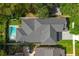 Aerial view of home with dark roof, lush landscaping, swimming pool, and driveway at 2510 Amherst Ave, Orlando, FL 32804