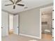 Bright bedroom featuring carpet flooring, ceiling fan and an open doorway to the bathroom at 2510 Amherst Ave, Orlando, FL 32804