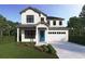 Two-story farmhouse-style home with a blue door and white garage at 2510 Amherst Ave, Orlando, FL 32804