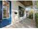 Covered front porch with pavers, a blue door, and a side window at 2510 Amherst Ave, Orlando, FL 32804
