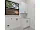 Bright laundry room featuring custom cabinets, modern fixtures, and unique tile flooring at 2510 Amherst Ave, Orlando, FL 32804