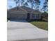 Single-story house with a two-car garage and landscaped lawn at 2950 Omaha Dr, Deltona, FL 32738