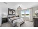 Spacious main bedroom with a large window, plush bedding, and dark accent wall at 3175 Emerald Acres Ln, Sanford, FL 32771