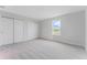 Bright bedroom with grey carpet, double doors to closet, and lake view at 33339 Seattle Slew Dr, Sorrento, FL 32776