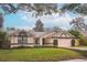 Single-story home with attached garage, well-manicured lawn, and mature trees at 4491 Yachtmans Ct, Orlando, FL 32812