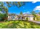 Tan house with a blue trim, two-car garage, and manicured lawn at 4491 Yachtmans Ct, Orlando, FL 32812