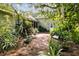 Brick patio surrounded by lush tropical plants and a large oak tree at 506 N Dillard St, Winter Garden, FL 34787