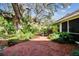 Red brick patio surrounded by tropical landscaping and a large oak tree at 506 N Dillard St, Winter Garden, FL 34787