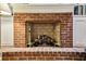 Close-up view of a brick fireplace with gas logs and brass andirons at 506 N Dillard St, Winter Garden, FL 34787