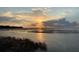 Scenic sunset over a tranquil lake with calm waters and reeds at 506 N Dillard St, Winter Garden, FL 34787