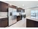 Modern kitchen with stainless steel appliances and dark cabinets at 5627 Costa Blanca Way, Davenport, FL 33897