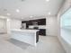 Modern kitchen with dark cabinets, white countertops and stainless steel appliances at 5627 Costa Blanca Way, Davenport, FL 33897