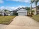 Gray house with blue shutters, landscaping, and a paved driveway at 644 Maya Susan Loop, Apopka, FL 32712