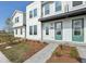 Modern townhome with light gray siding, green doors, and attractive landscaping at 6581 Quest St, St Cloud, FL 34771