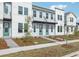 Three-unit townhome building showcasing modern design, landscaping, and a light color scheme at 6581 Quest St, St Cloud, FL 34771