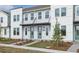 Modern townhome building with light gray siding, green doors, and attractive landscaping at 6581 Quest St, St Cloud, FL 34771