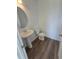 Modern powder room with pedestal sink and updated flooring at 6581 Quest St, St Cloud, FL 34771