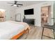 Modern bedroom with king bed, dresser, and access to another room at 701 Grant Ave, Mount Dora, FL 32757