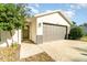 Front view of a house with a gray garage door and a walkway at 701 Grant Ave, Mount Dora, FL 32757