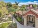 Aerial view of clubhouse entrance and landscaping, featuring palm trees and a water fountain at 832 Grand Regency Pt # 102, Altamonte Springs, FL 32714