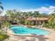 Community pool with a beach-style entry, lush landscaping, and a view of the surrounding buildings at 832 Grand Regency Pt # 102, Altamonte Springs, FL 32714