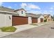 Attached garages with brown doors and landscaping at 8757 Via Tavoleria Way, Windermere, FL 34786