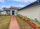 Home's exterior features a dark blue front door and neatly manicured landscaping at 8813 Parliament Ct, Kissimmee, FL 34747