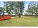 Large backyard with grass, trees, and a wooden deck at 922 Wyoming Ave, St Cloud, FL 34769