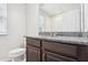 Bathroom with granite countertop, dark brown vanity, and a toilet at 9457 Randal Park Blvd, Orlando, FL 32832