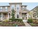 Two-story townhome with neutral siding, landscaped yard, and covered porch at 9457 Randal Park Blvd, Orlando, FL 32832