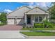 Single-story home with two-car garage, stone accents, and manicured landscaping at 9693 Lost Creek Dr, Winter Garden, FL 34787