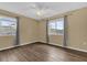 Bedroom with wood-look floors, ceiling fan and two windows with curtains at 107 Japonica Dr, Orlando, FL 32807