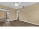 Bedroom with wood-look floors, mirrored closet and access to another room at 107 Japonica Dr, Orlando, FL 32807