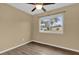 Cozy bedroom with wood-look floors, ceiling fan, and a window with a view at 107 Japonica Dr, Orlando, FL 32807