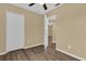 Bedroom with wood-look floors, ceiling fan, and access to another room at 107 Japonica Dr, Orlando, FL 32807