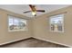 Bedroom with wood-look floors, ceiling fan and two windows at 107 Japonica Dr, Orlando, FL 32807
