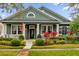 Green house with white columns and landscaping at 13055 Lake Live Oak Dr, Orlando, FL 32828