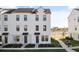 Three-story townhome with white siding, gray accents, and landscaping at 15100 Grove Lake Dr, Winter Garden, FL 34787