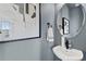Stylish powder room with round mirror and modern sink at 15100 Grove Lake Dr, Winter Garden, FL 34787